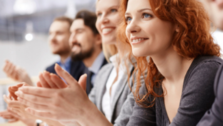 Enthusiastic young professionals appear to be listen to an exciting message while at work.