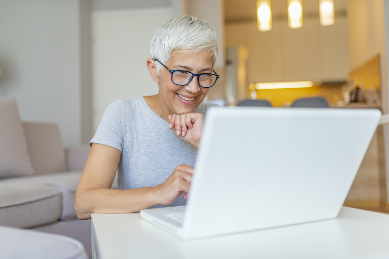 woman smiling and looking at laptop