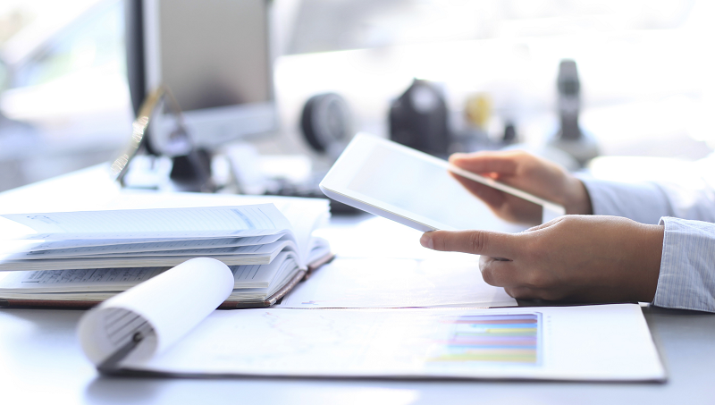 close up of person at a desk holding a tablet