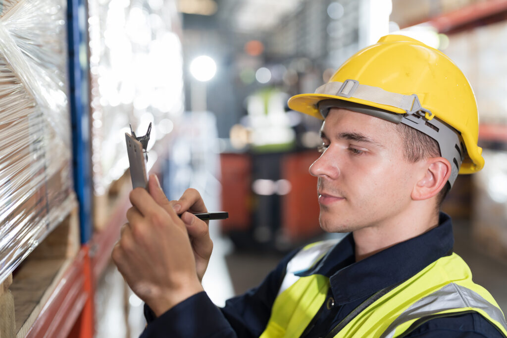 Warehouse worker scanning barcodes on boxes on a shelf