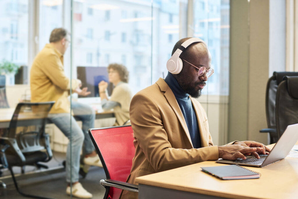 Employee wearing headphones working at a laptop