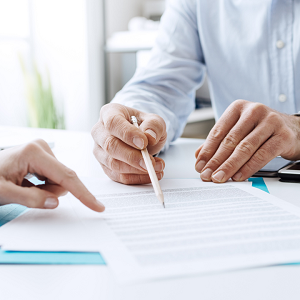 two sets of hands reviewing a document