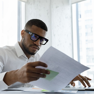 man with glasses looking at a piece of paper