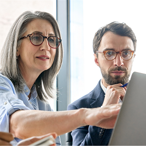 Woman and man at a computer with the woman reaching to touch the screen