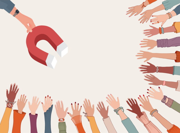 Illustration of a diverse group of outstretched hands reaching toward a large red horseshoe magnet held by a hand wearing a watch. The hands vary in skin tone, clothing, and accessories, symbolizing attraction, recruitment, or audience engagement.