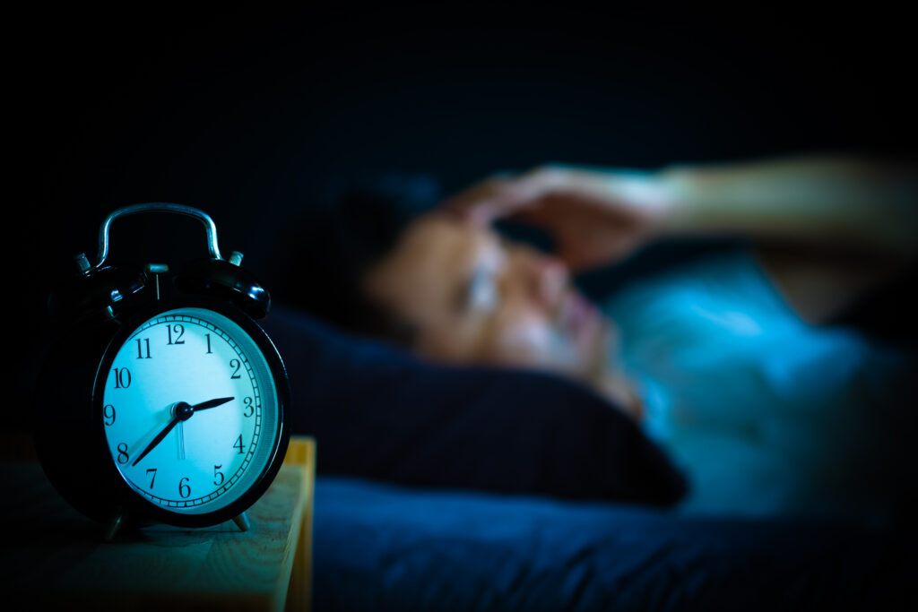 asian man in bed suffering insomnia and sleep disorder thinking about his problem at night