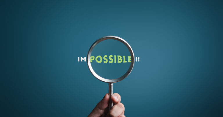 Magnifier focuses on word POSSIBLE side of the word IMPOSSIBLE. It is possible to motivational inspirational concepts. Unveiling the motivation concept. Blue background, flat lay.