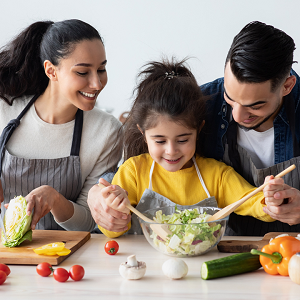 parents with a child making a salad