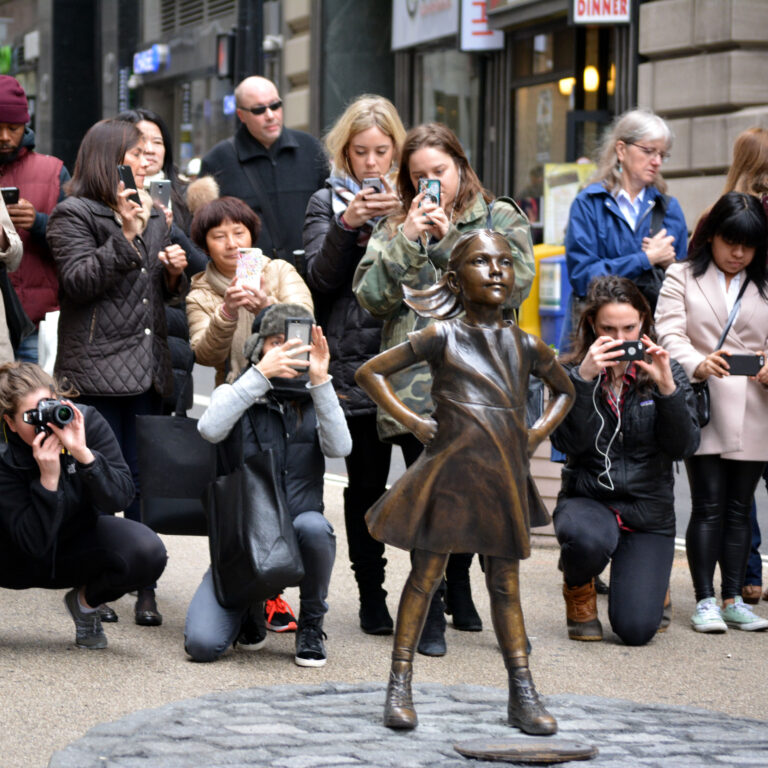 People gathering around "The Fearless Girl" statue placed in Lower Manhattan to help mark International Women's Day.